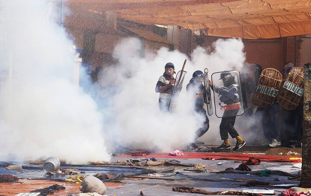 Police use tear gas to disperse supporters, as they storm the ashram of controversial guru Sant Rampal, at Hisar in Haryana.