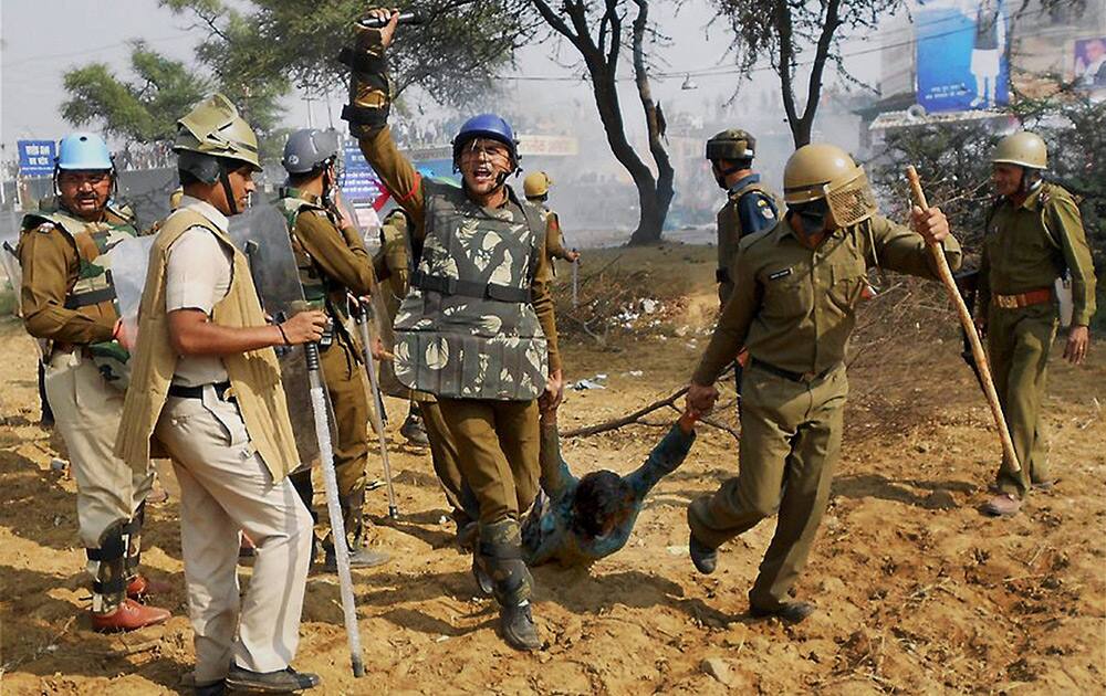 Security personnel drag away a follower of Sant Rampal during a clash outside Satlok Ashram in Hisar. Supporters of Rampal indulged in clashes with the police to resist his arrest.