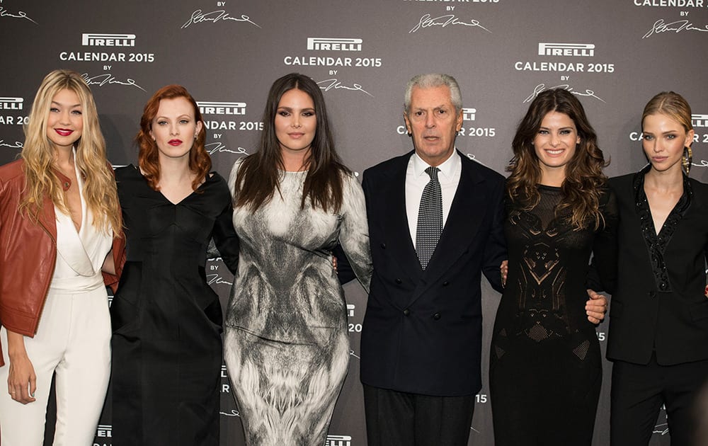 CEO Pirelli Group Marco Tronchetti Provera, fourth from left, poses with some of the models of the Pirelli 2015 Calendar by Steven Meisel, unveiled in Milan, Italy. From left, Gigi Hadid, Karen Elson, Candice Huffine, Isabeli Fontana and Sasha Luss. 