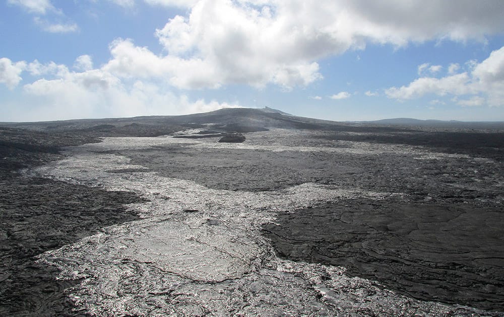 lava flow from the Kilauea Volcano that began on June 27 with Puu Oo shown at the rear center near Pahoa, Hawaii. Kilauea has been erupting continuously for more than 31 years.