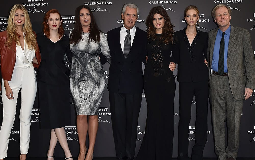 CEO Pirelli Group Marco Tronchetti Provera, fourth from left, poses with some of the models of the Pirelli 2015 Calendar by Steven Meisel unveiled in Milan.