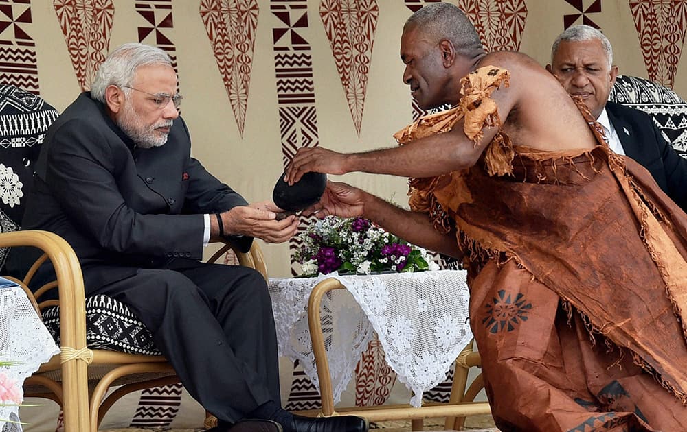 Prime Minister Narendra Modi with a performer during a traditional welcome ceremony in Fiji.