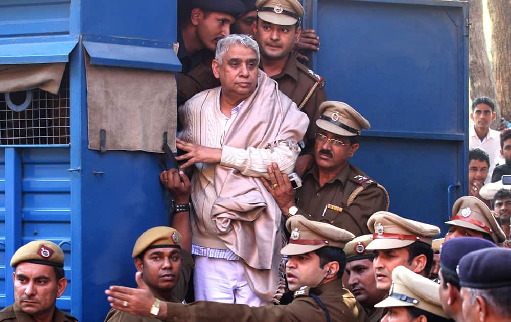 Controversial religious leader Sant Rampal stands by the door of a police van as he is brought to a court, surrounded by police personnel in Chandigarh.