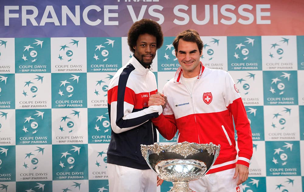 Switzerland's Roger Federer, poses with France's Gael Monfils during the Davis Cup final draw in Lille, northern France.