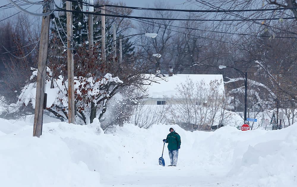 A man takes a break from shoveling in the south Buffalo area, in Buffalo, N.Y. A new blast of lake-effect snow pounded Buffalo for a third day piling more misery on a city already buried by an epic, deadly snowfall that could leave some areas with nearly 8 feet of snow on the ground when it's all done.