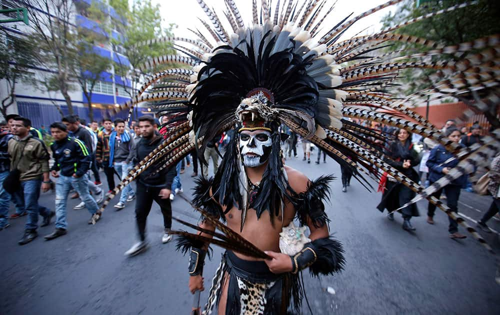 A protester dressed in an Aztec costume walks during a massive march in Mexico City. Protesters marched to demand authorities find 43 missing college students, trying to step up pressure on the government on a day traditionally reserved for the celebration of the 1910-17 Revolution.