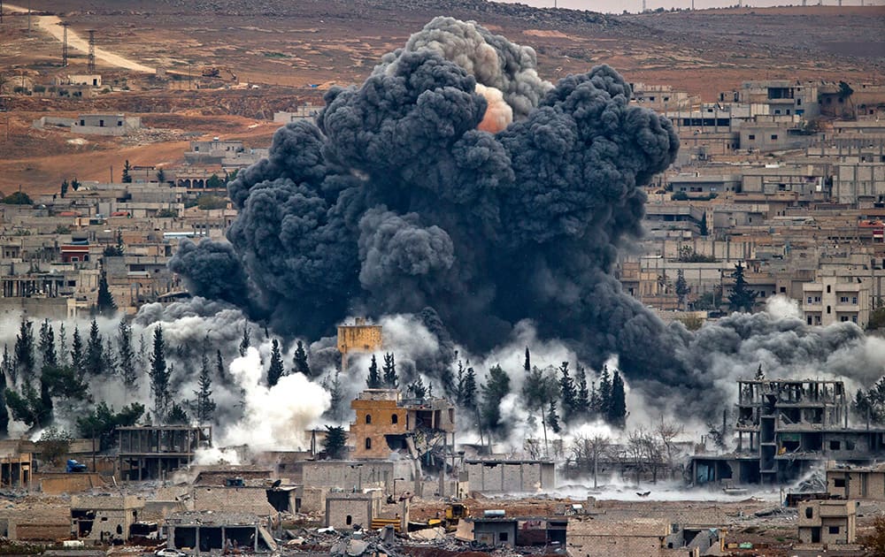 Smoke rises from the Syrian city of Kobani, following an airstrike by the US-led coalition, seen from a hilltop outside Suruc, on the Turkey-Syria border.