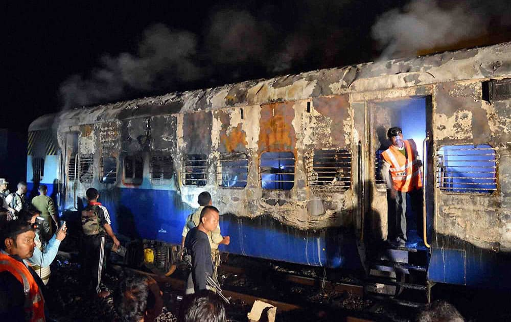 Rescuers and army personnel inspect a compartment of a special train which caught fire. The special train carrying army personnel was on its way to Jammu from Dimapur.