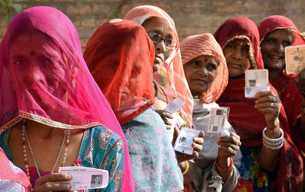 Voters showing their voter ID cards outside a polling booth during local municipal elections in Bikaner.