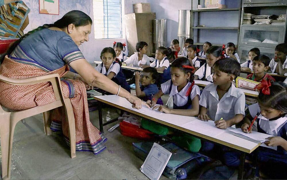 Gujarat Chief Minister Anandiben Patel interacts with school children in a classroom on the occasion of her birthday in Gandhinagar.