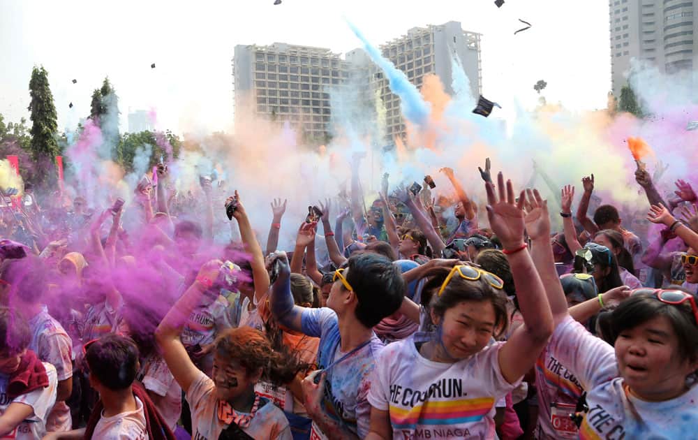 Participants throw colored powder into the air during the Color Run in Jakarta, Indonesia.