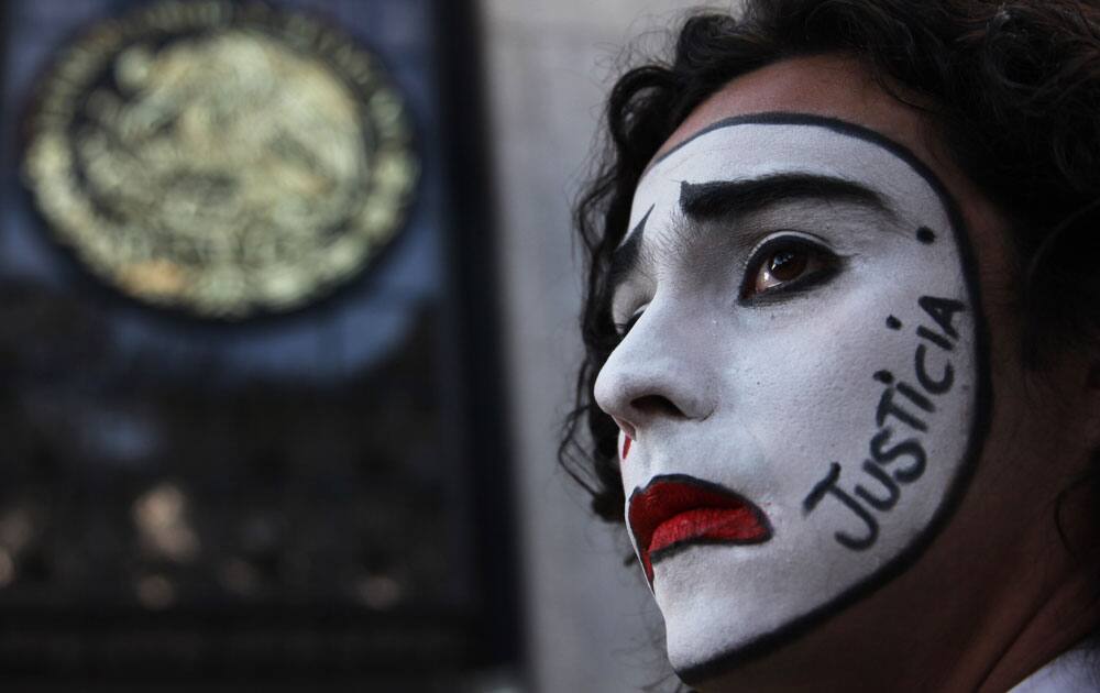 A student wearing white clown makeup with the Spanish word for 