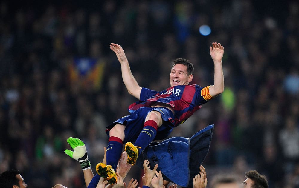 FC Barcelona's Lionel Messi, from Argentina, is lifted by his teammates after scoring against Sevilla during a Spanish La Liga soccer match between FC Barcelona and Sevilla, at the Camp Nou stadium in Barcelona, Spain.