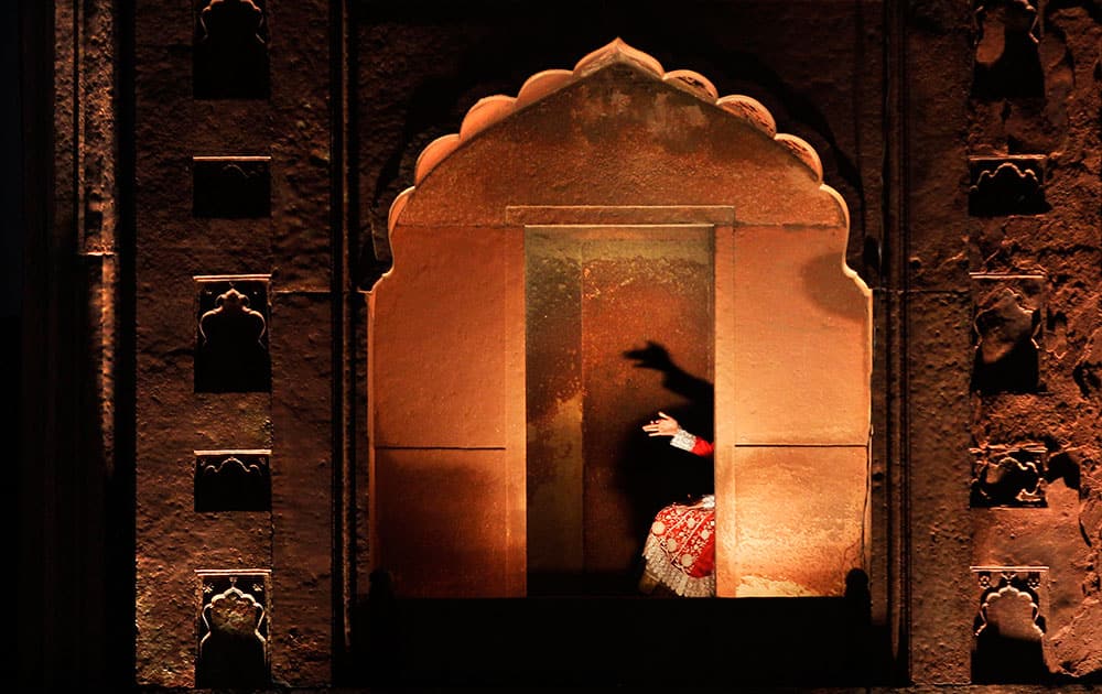 A young Indian Muslim girl, attending the anointment ceremony of Syed Shaban Bukhari, makes hand shadow puppets on a wall of the Jama Masjid in New Delhi, India.