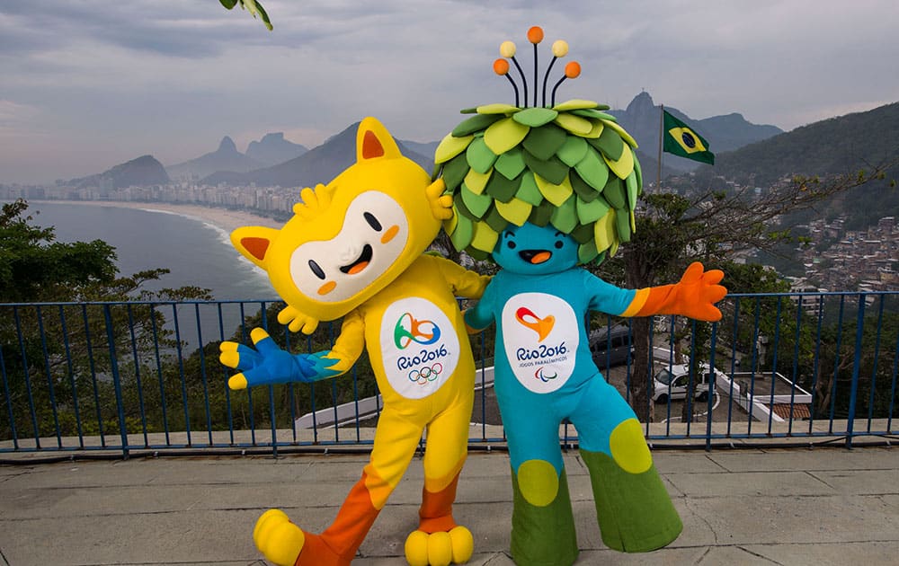 In this photo released by Rio 2016 Organizing Committee for the Olympic and Paralympic Games, the mascots of Rio 2016 Olympic, left, and Paralympic Games pose for a photo at the Leme Fort, with Copabana beach, left, in the background, in Rio de Janeiro, Brazil.