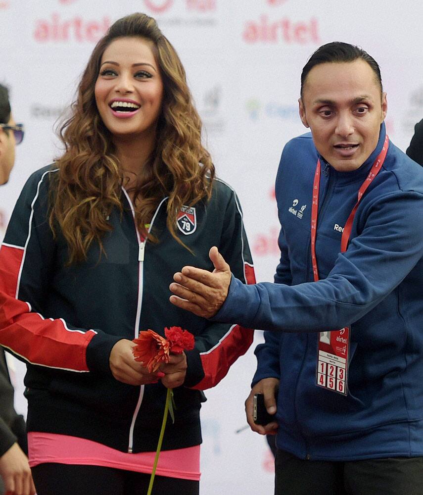 Bollywood actors Rahul Bose and Bipasha Basu cheer the participants of Airtel Delhi Half Marathon in New Delhi.