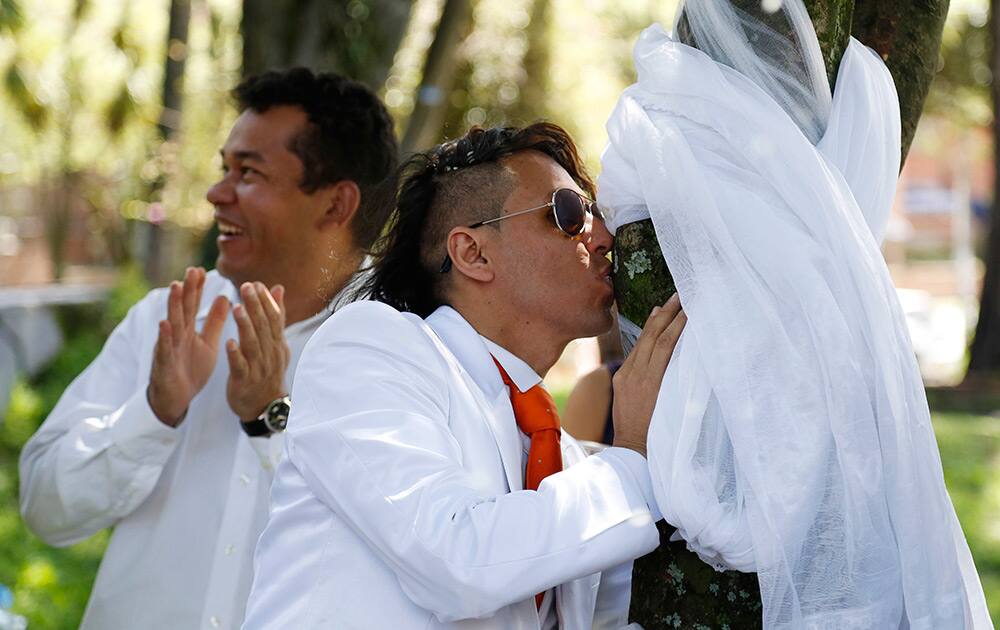 Peruvian environmental activist Richard Torres kisses a tree after a symbolic marriage to it at the National park in Bogota, Colombia.