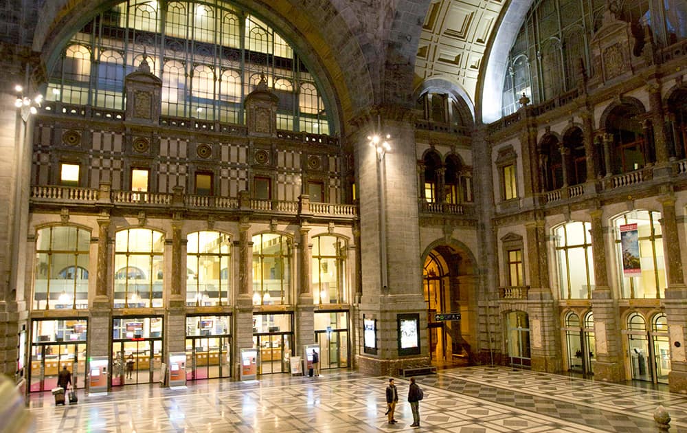 Two people stand in the main hall of Antwerp Central train station during morning rush hour in Antwerp, Belgium. On Monday trade unions opened a month of intermittent strike actions by paralyzing the port of Antwerp and slowing train traffic through much of Belgium. All trains running out of Antwerp were cancelled.