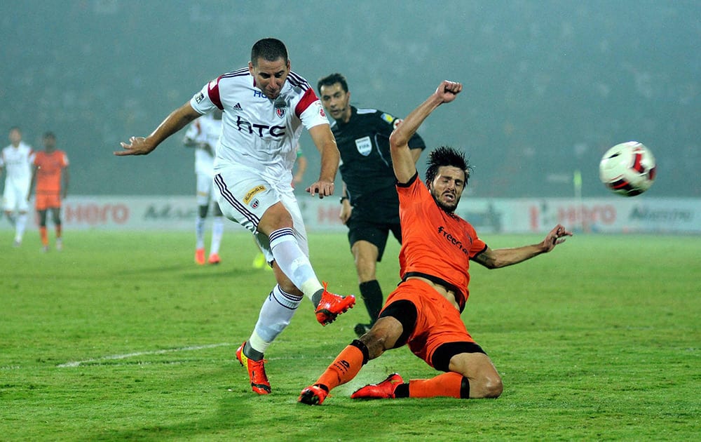 Players of North East United FC (in white) and Delhi Dynamos FC (in orange) in action during their ISL match, at Indira Gandhi Stadium in Guwahati.