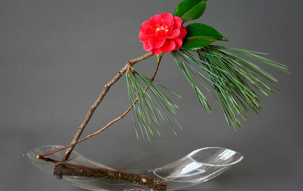 This photo provided by KeithStanley.com shows Ikebana using pine and red camellia branches.The ancient Japanese art of ikebana, or flower arranging, can offer lots of festive sparkle and color for the holidays - and a more modern feel that celebrates asymmetry, space and naturalism.