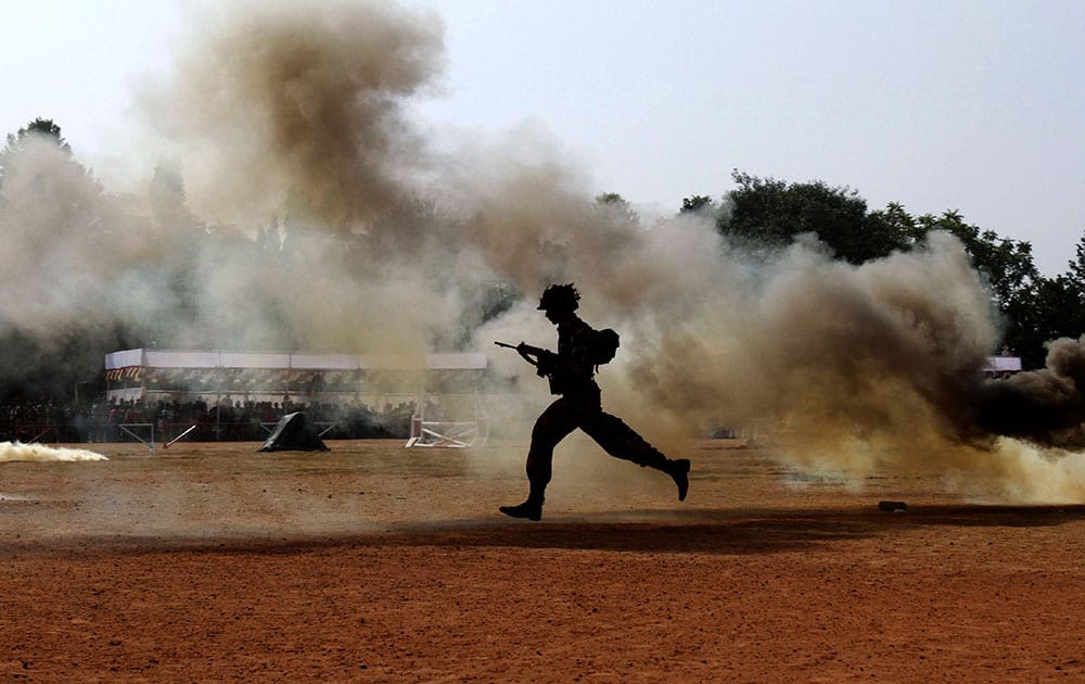 An Indian student dressed like an army soldier runs to take position during a drill to mark the National Cadets Corps (NCC) Day in Bhubaneswar, India.