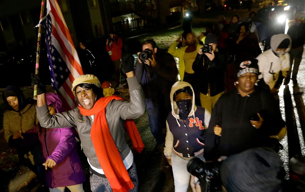 Protesters march, along a stretch of road where violent protests occurred following the August shooting of unarmed black teenager by a white police officer in Ferguson, Mo.