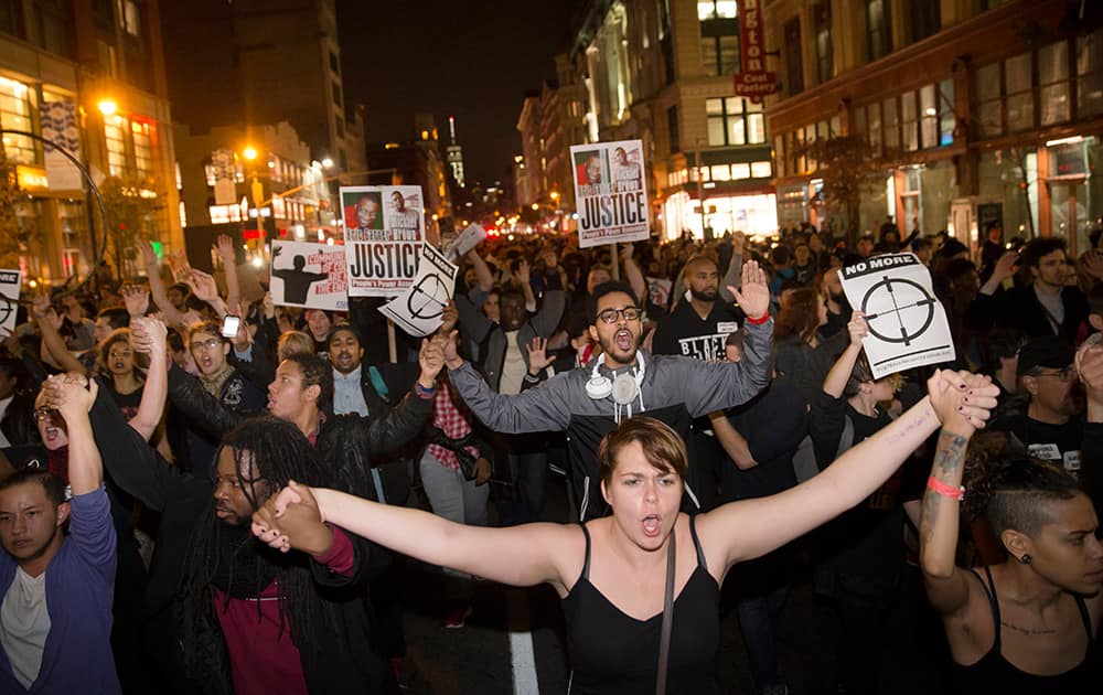 Protestors clasp hands as they march up Seventh Avenue towards Times Square after the announcement of the grand jury decision not to indict police officer Darren Wilson in the fatal shooting of Michael Brown, in New York.