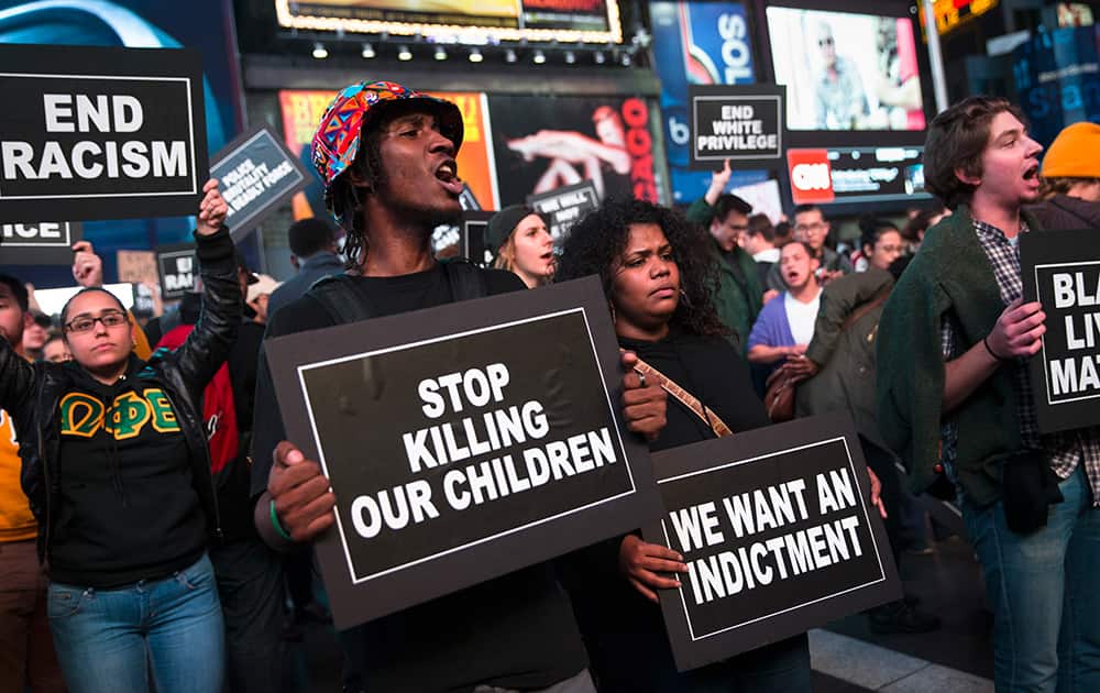 Protestors hold signs during a demonstration in Times Square after the announcement of the grand jury decision not to indict Ferguson police officer Darren Wilson in the fatal shooting of Michael Brown, in New York.