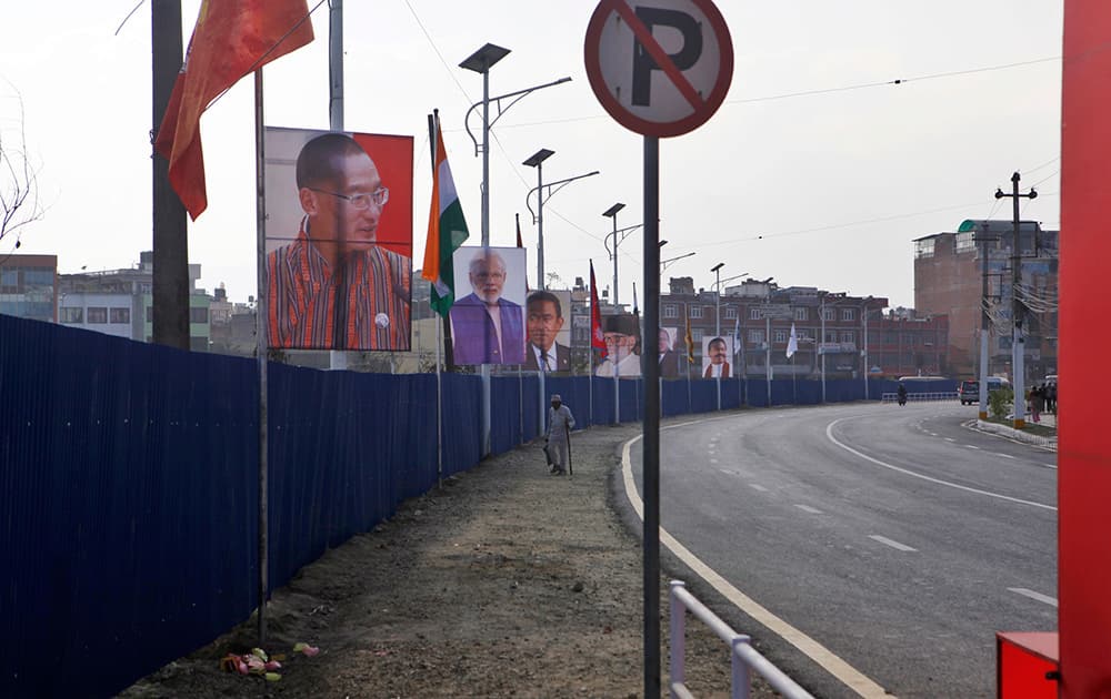 An elderly Nepalese man walks past portraits of heads of South Asian Association for Regional Cooperation (SAARC), countries displayed on a road side in Katmandu, Nepal.