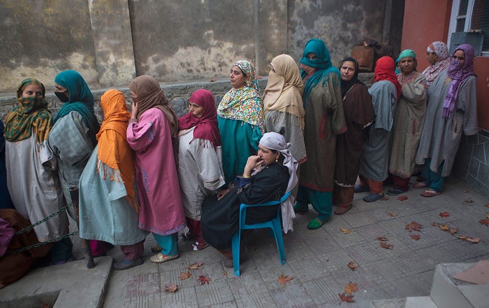 Kashmiri women wait in a queue to cast their votes during the first phase of polling to the Jammu and Kashmir state assembly elections in Lar, some 30 kilometers (19 miles) north of Srinagar.