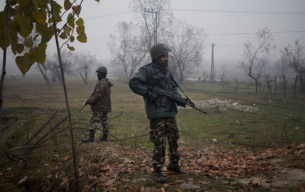 Paramilitary soldiers stand guard beside a highway during the first phase of voting to the Jammu and Kashmir state assembly elections in Ganderbal, about 20 kilometers (12 miles) north east of Srinagar.