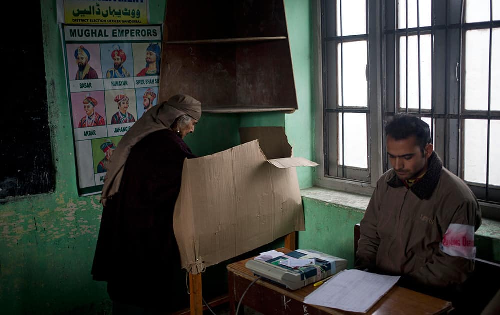 An elderly Kashmiri woman casts her vote at a polling station set up inside a school during the first phase of voting to the Jammu and Kashmir state assembly elections in Ganderbal, about 20 kilometers (12 miles) north east of Srinagar.