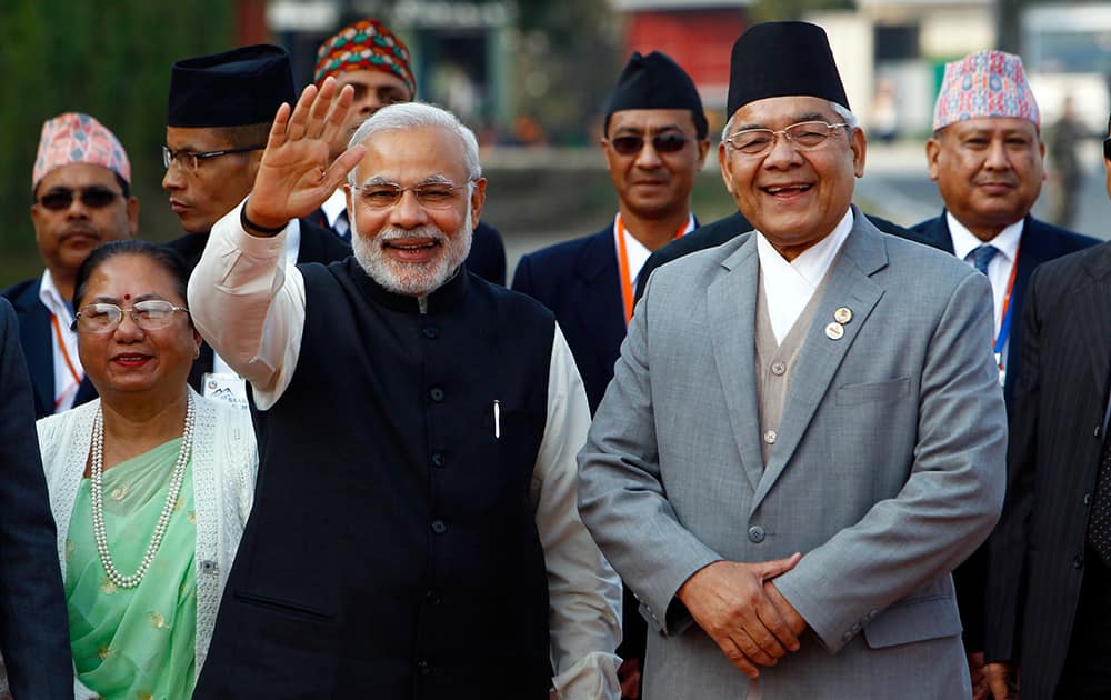 Prime Minister Narendra Modi, waves to the media as he is received by Nepalese Home Minister Bam Dev Gautam, upon arrival at the Tribhuwan Airport to attend the 18th summit of South Asian Association for Regional Cooperation (SAARC) in Katmandu, Nepal.