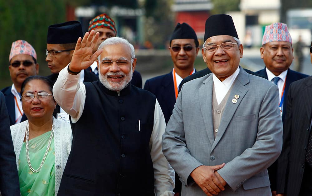 PM Narendra Modi, waves to the media as he is received by Nepalese Home Minister Bam Dev Gautam, upon arrival at the Tribhuwan Airport to attend the 18th summit of South Asian Association for Regional Cooperation (SAARC) in Katmandu, Nepal.
