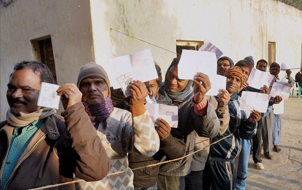 Voters wait to cast their votes during the first phase of Jharkhand assembly elections at a polling station in Lohardaga.