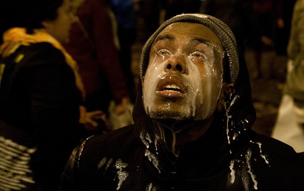 A protestor pours milk in his eyes after being tear gassed by Seattle police at the Interstate 5 entrance on Cherry Street in Seattle.