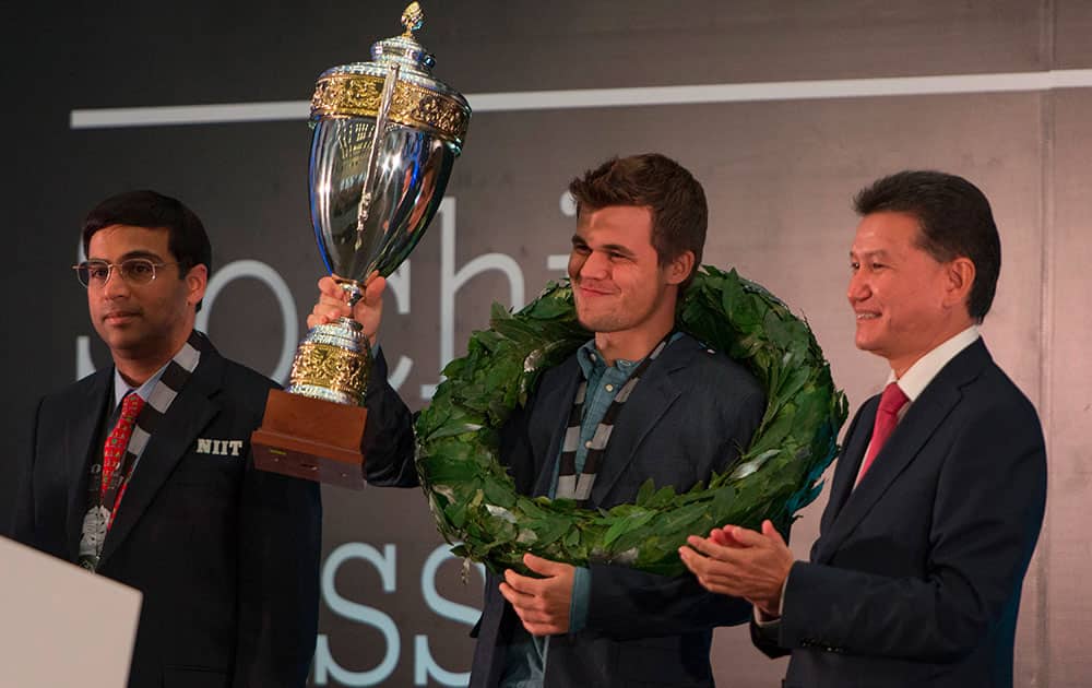 Norway's Magnus Carlsen shows his trophy at an award ceremony of the FIDE World Chess Championship Match in Sochi, Russia.