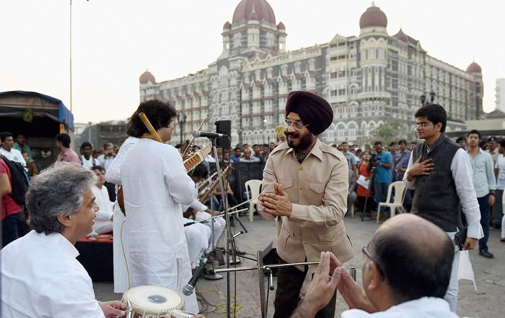 Maninderjeet Singh Bitta, chairman of All-India Anti-Terrorist Front greets musicians at a music concert to pay tribute to the 26/11 Mumbai Terror Attack martyrs at Gateway of India in Mumbai.