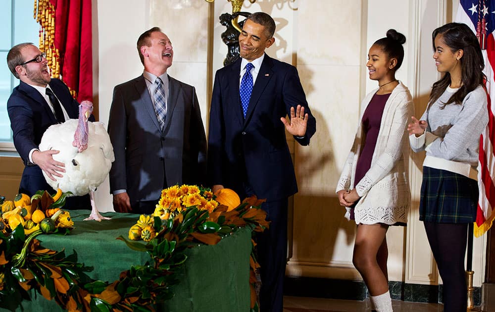 President Barack Obama gestures that his daughters Sasha, second from right, and Malia, right, would rather pass on touching 