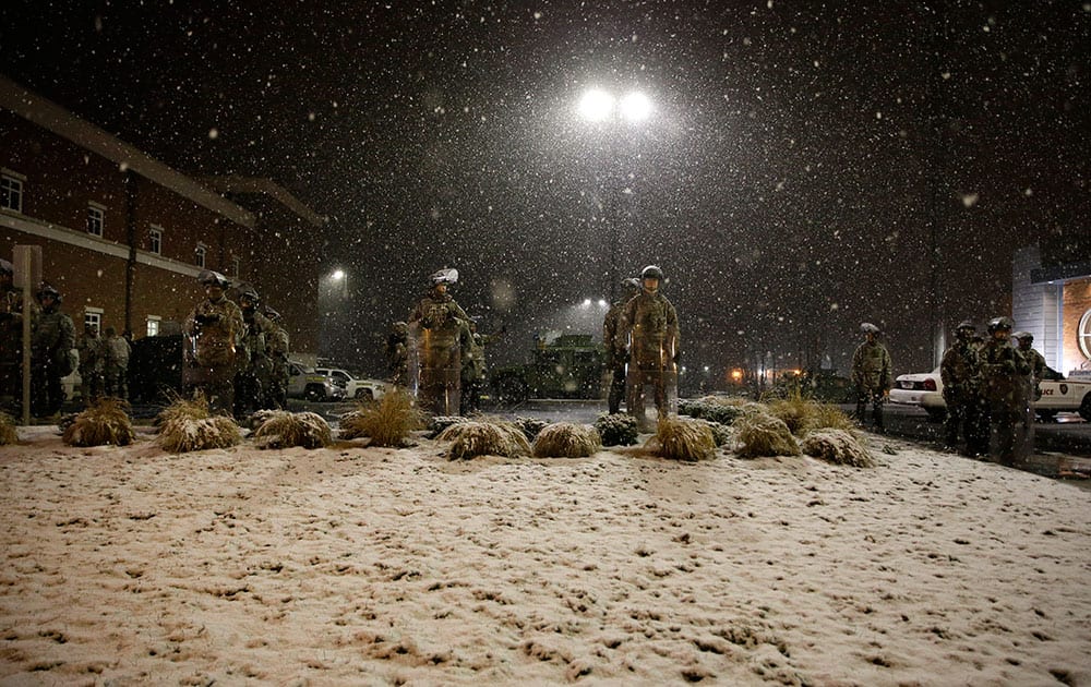 SNOW FALLS AS MISSOURI NATIONAL GUARD STAND OUTSIDE OF THE FERGUSON POLICE DEPARTMENT IN FERGUSON, MO.