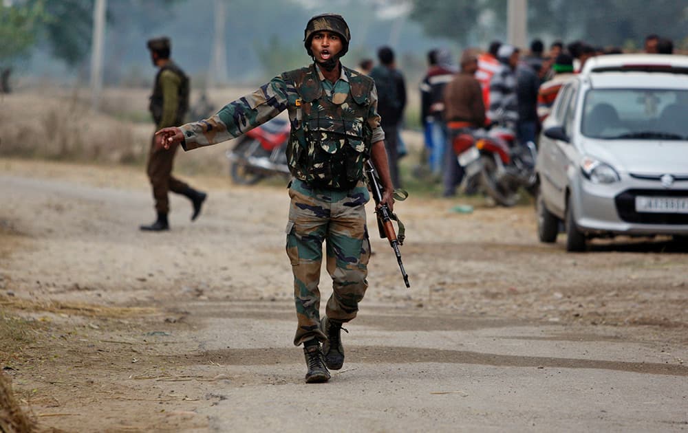 An Indian Army soldier gives orders to his colleagues during exchange of gunfire with armed militants at Pindi Khattar village in Arnia border sector, 43 kilometers (27 miles) south of Jammu.