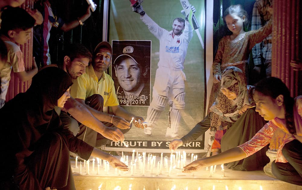 Pakistani cricket fans light candles to pay tribute to Australian cricketer Phillip Hughes in Karachi, Pakistan.