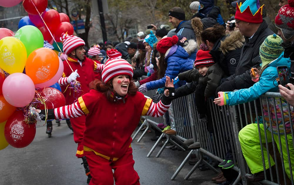 A performer cheers as she skates by spectators during the Macy's Thanksgiving Day Parade, in New York.