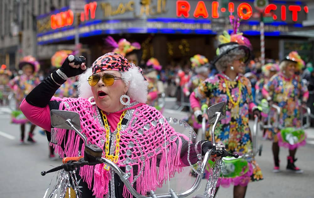 Performers with the Red Hot Mamas troupe march past Radio City Music Hall along Sixth Avenue during the Macy's Thanksgiving Day Parade, in New York.