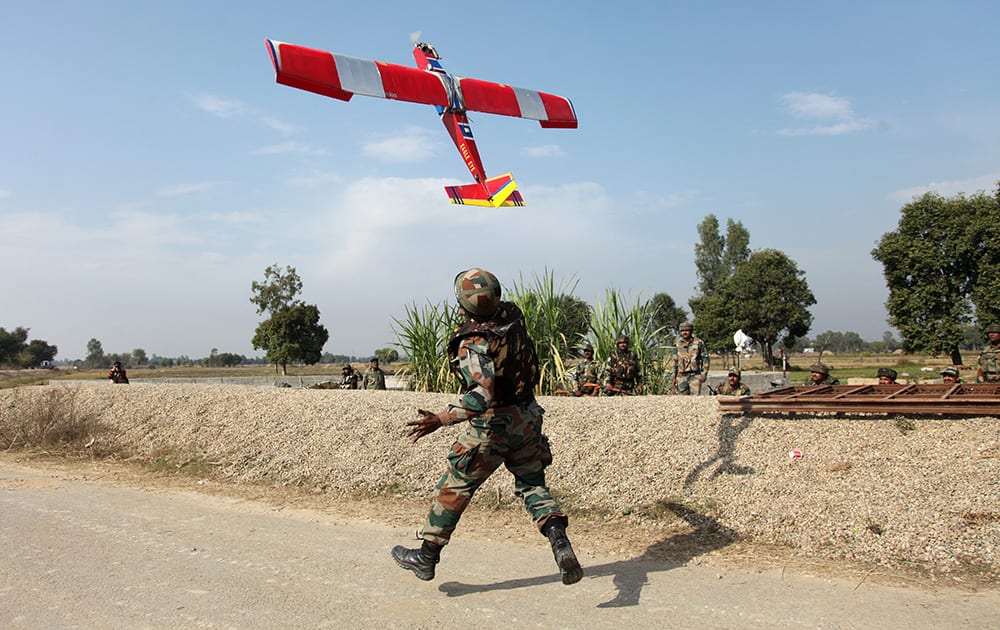 An Indian army soldier runs after a drone being sent for surveillance during a gunbattle with armed militants at Pindi Khattar village in Arnia border sector, about 43 kilometers (27 miles) south of Jammu.