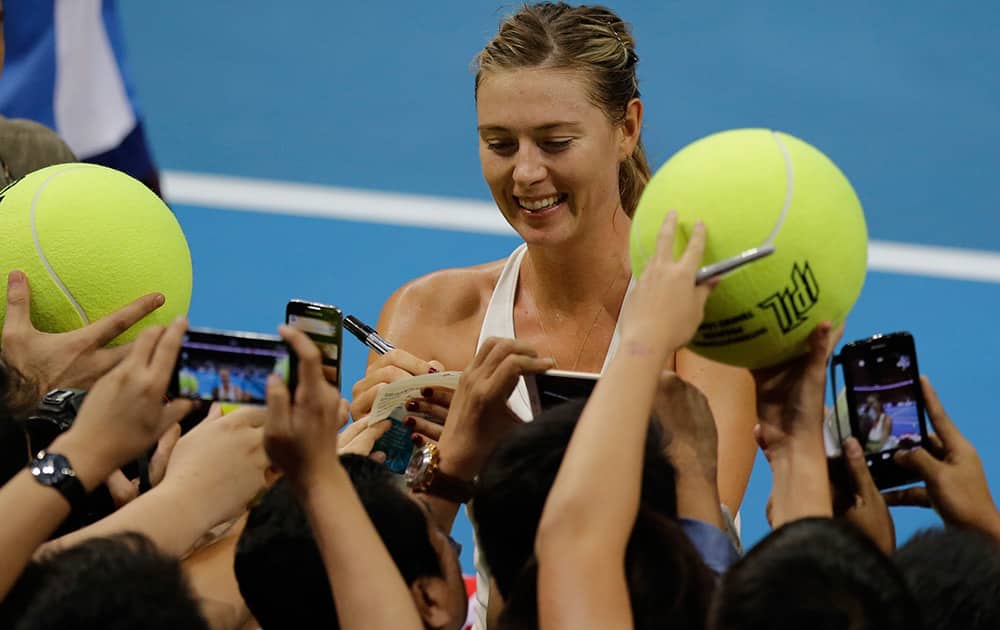 Maria Sharapova of the Manila Mavericks autographs large tennis balls of fans following her win over Kristina Mladenovic of the UAE Royals in their IPTL (International Premier Tennis League) Women's Singles match at the Mall of Asia Arena at suburban Pasay city, south of Manila, Philippines.