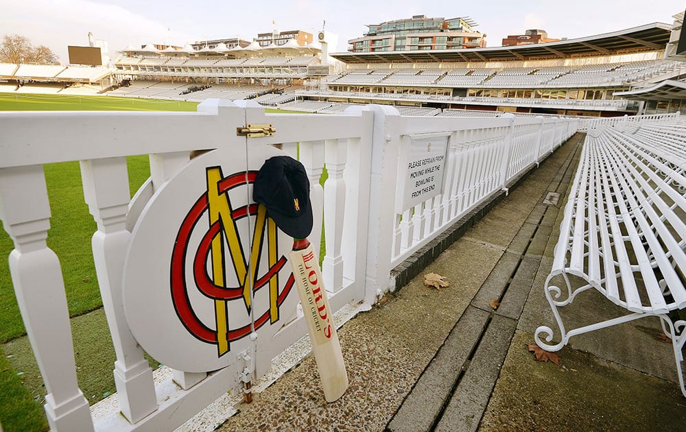 A cricket bat and cap rest against the boundary fence at Lord's Cricket Ground, the home of modern cricket, in London, in memory of Phillip Hughes, who died after injuries suffered when he was struck on the head by a bouncer at the Sydney Cricket Ground.