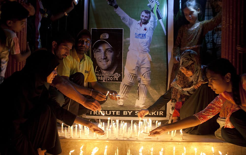 Pakistani cricket fans light candles to pay tribute to Australian cricketer Phillip Hughes in Karachi, Pakistan.