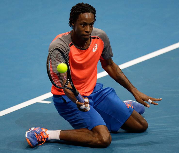 Gael Monfils of the Indian Aces kneels to return a shot from opponent Lleyton Hewitt of Singapore Slammers during their IPTL (International Premier Tennis League) singles match at the Mall of Asia Arena at suburban Pasay city, south of Manila, Philippines. 