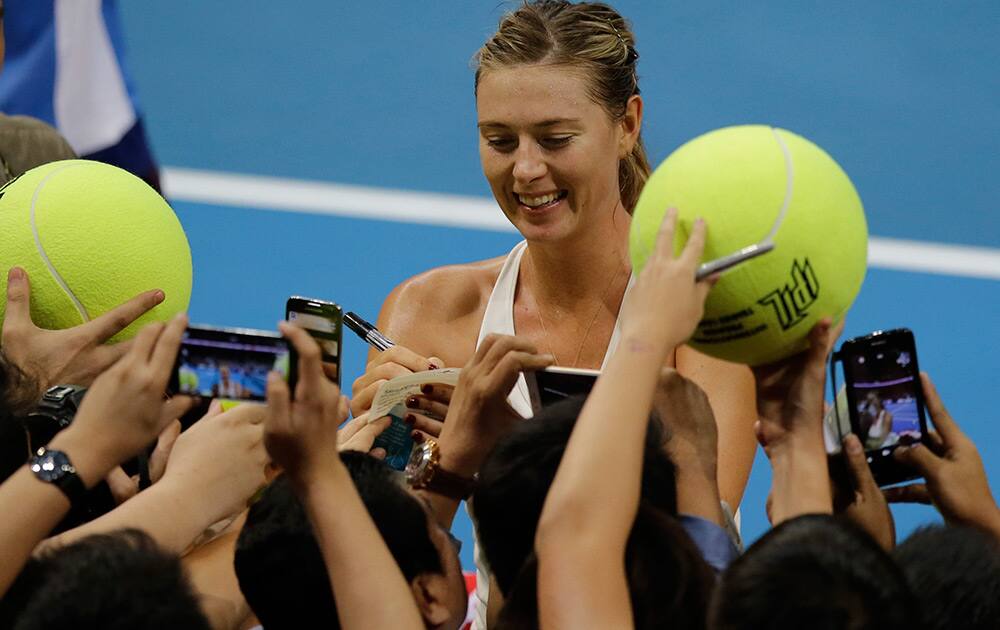 Maria Sharapova of the Manila Mavericks autographs large tennis balls of fans following her win over Kristina Mladenovic of the UAE Royals in their IPTL (International Premier Tennis League) Women's Singles match at the Mall of Asia Arena at suburban Pasay city, south of Manila, Philippines. 